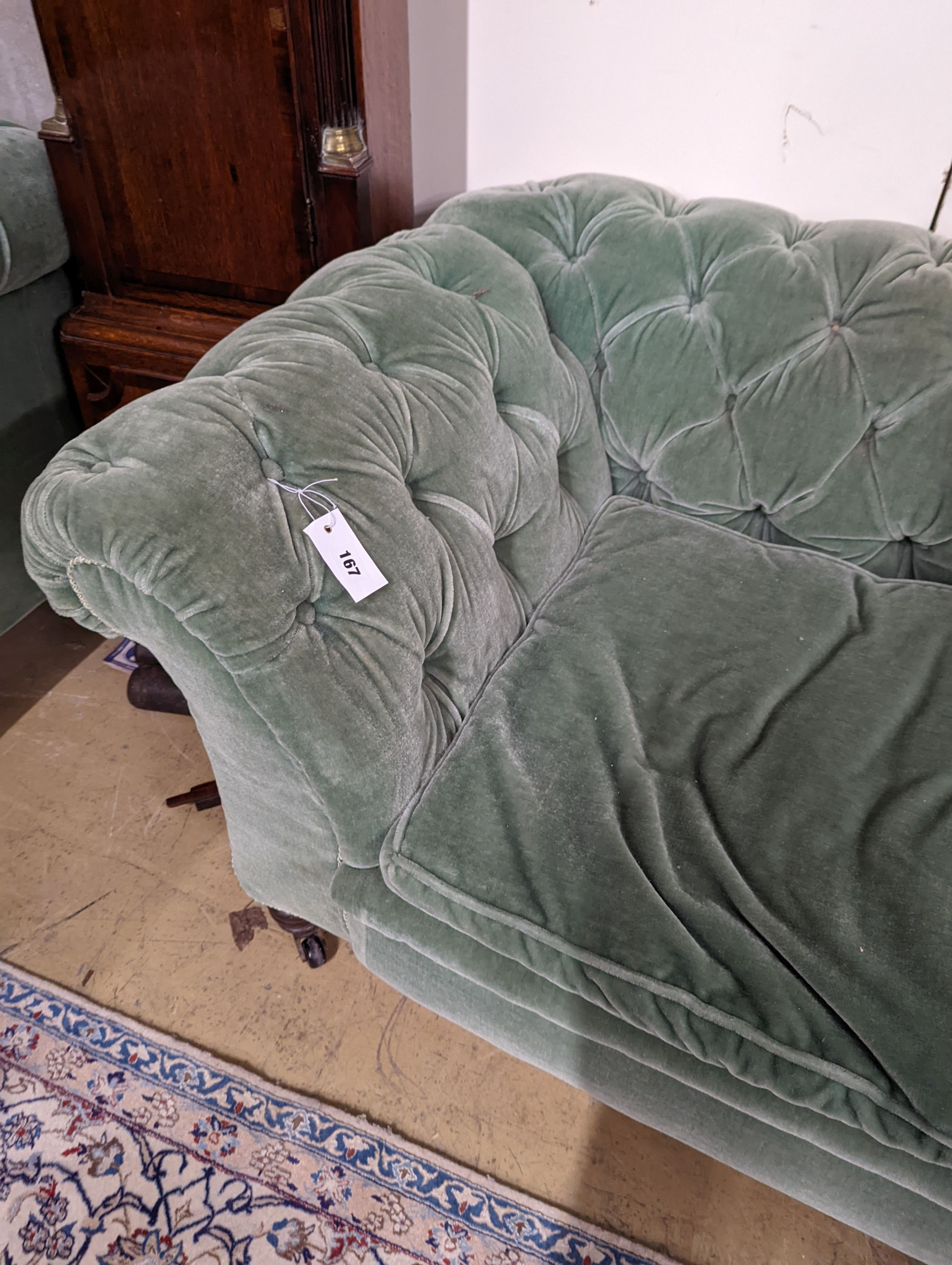 A late Victorian double drop arm Chesterfield settee upholstered in green fabric, length 186cm, depth 84cm, height 70cm